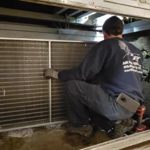 A man is working on an air conditioner.