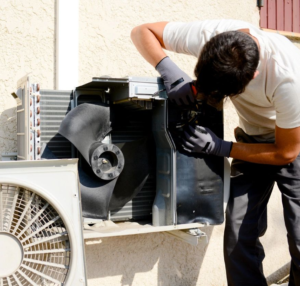 A man working on an air conditioner outside.