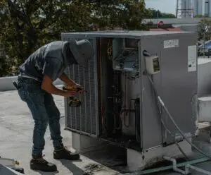 A man working on an air conditioner unit.